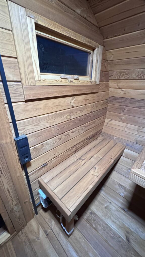Holzbank im Vorraum der Oval Sauna mit Fenster